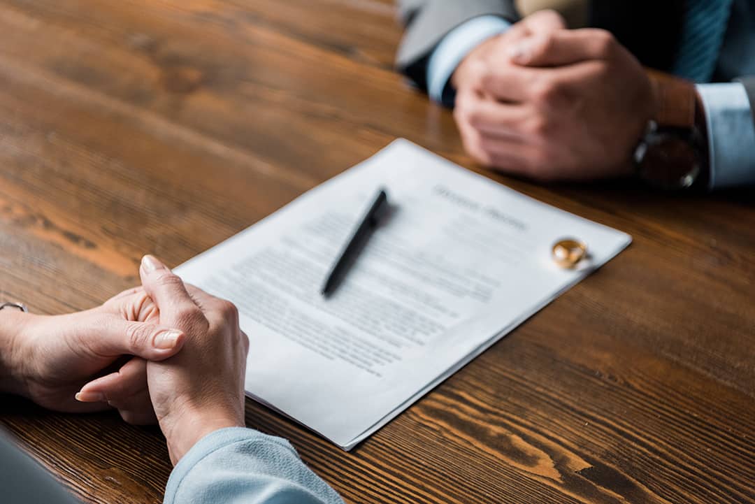 partiapartial view of lawyer and client sitting at table with divorcel view of lawyer and client sitting at table with divorce