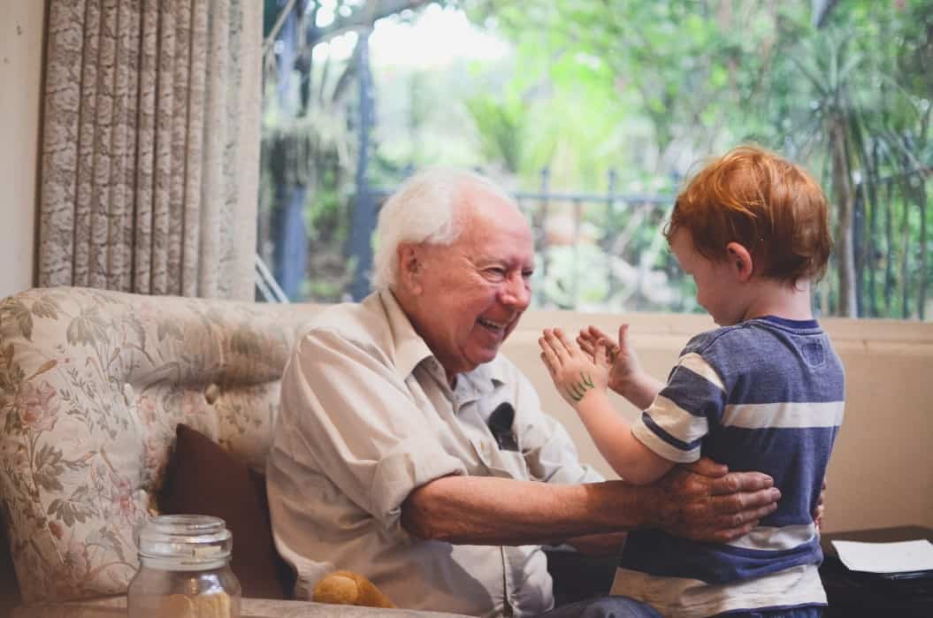 Grandparent smiling at his young grandson